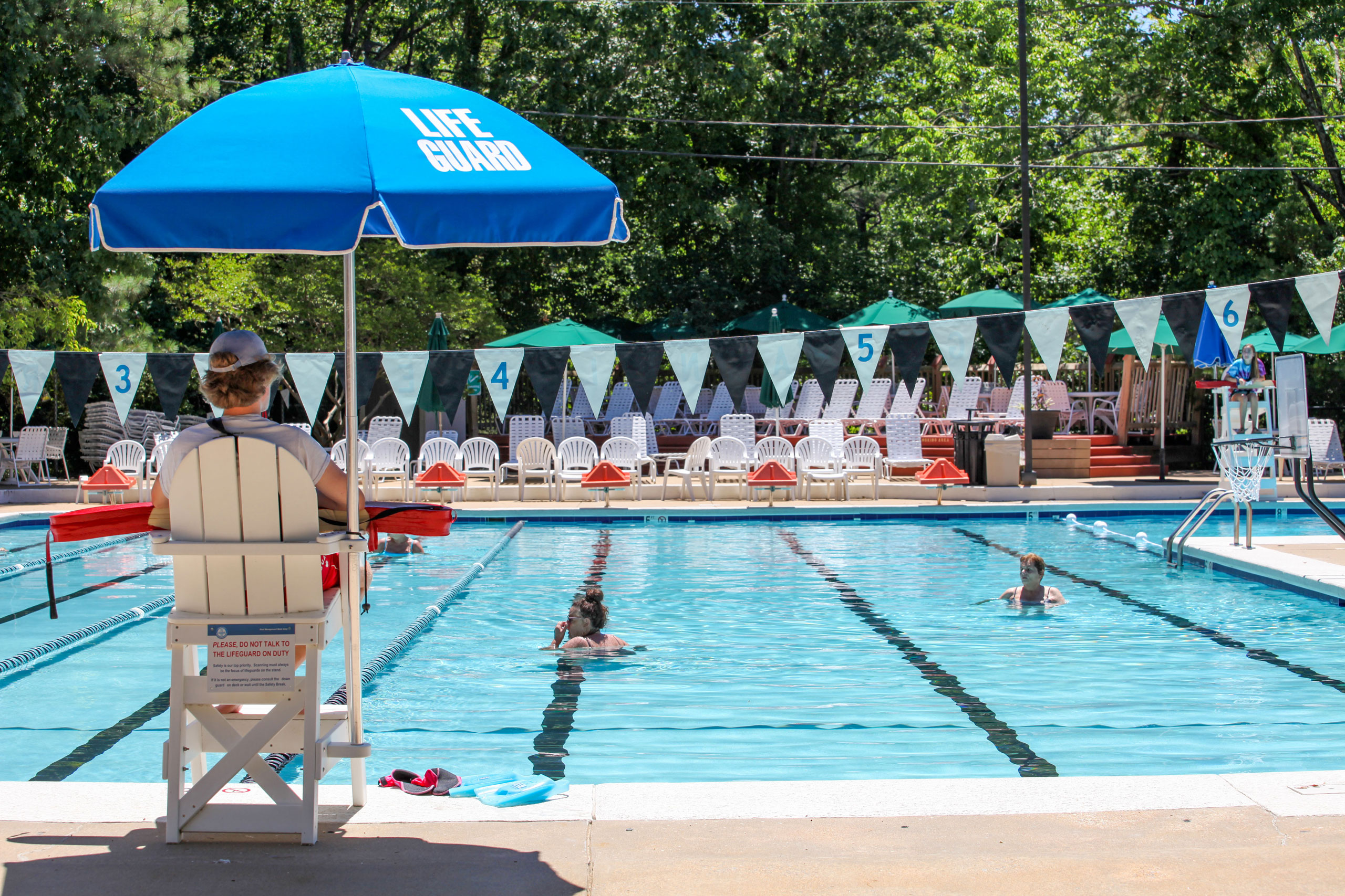 Male lifeguard on duty watching kids in the pool