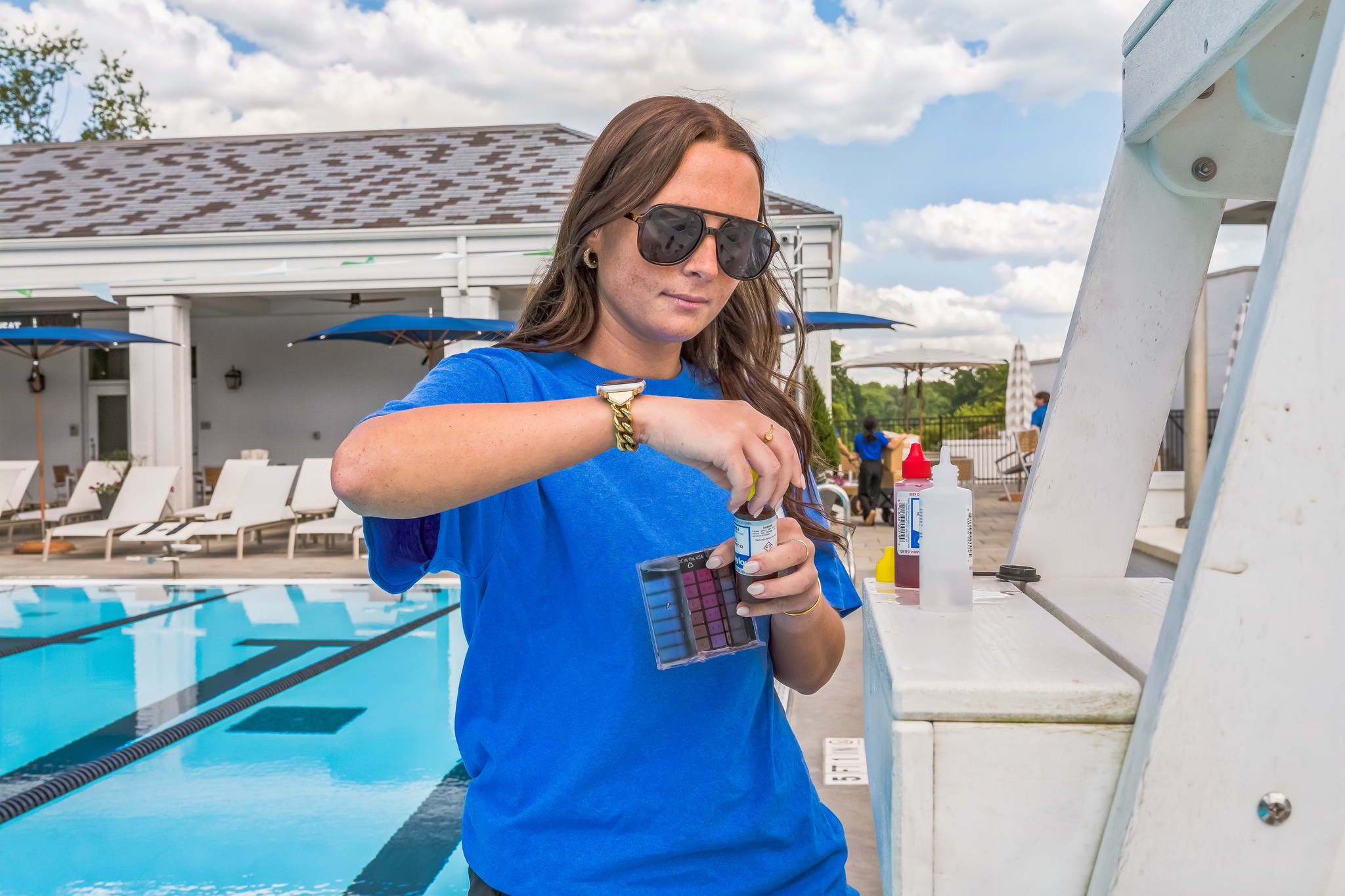 Young female employee checking chemical levels at an HOA pool