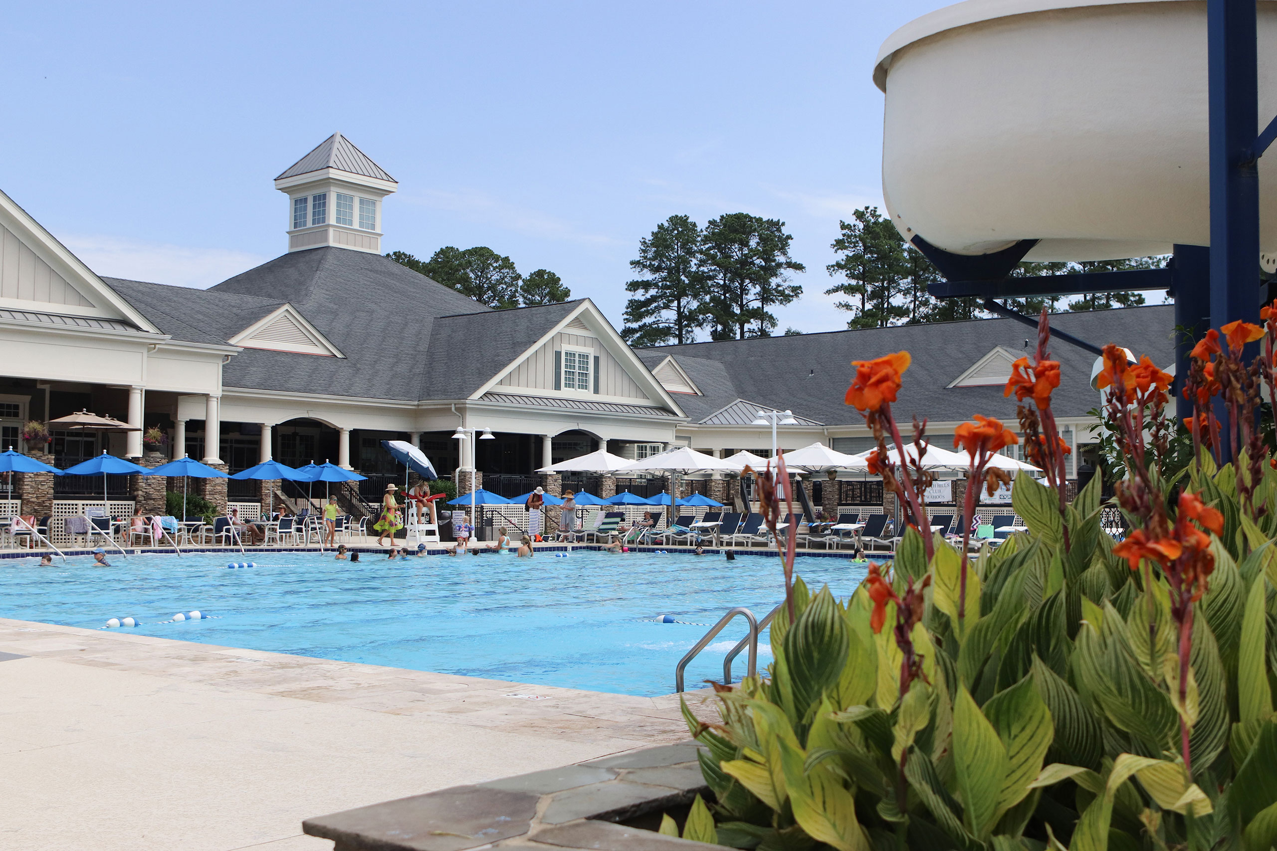 community swimming pool with people in the water and along the pool deck